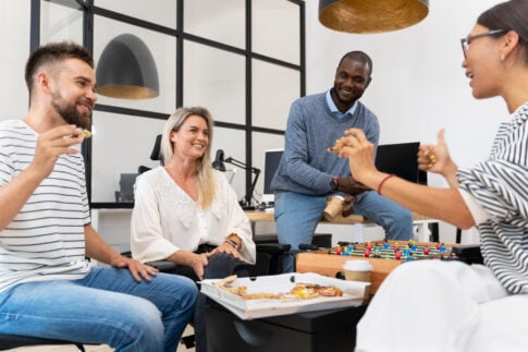 Adults talking together around a table in an office lounge